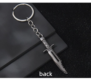 Silver metallic dagger keychain model shown on a textured dark pedestal back view