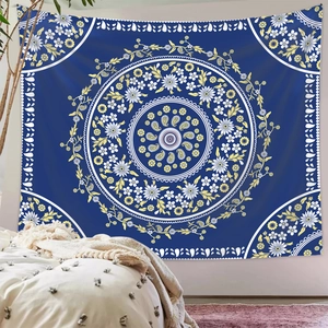 Blue mandala tapestry with floral patterns hanging in a cozy bedroom setting