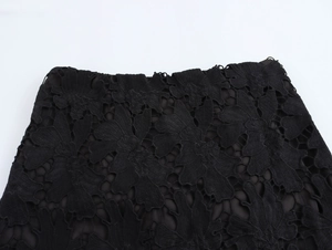 Dettaglio ravvicinato del tessuto in pizzo floreale nero con delicati motivi traforati