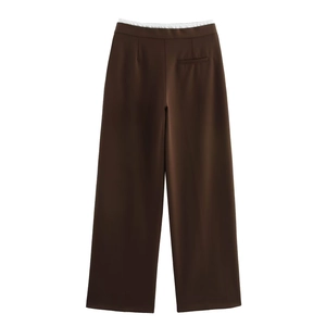Close-up of dark brown wide-leg trousers featuring a white layered waistband design