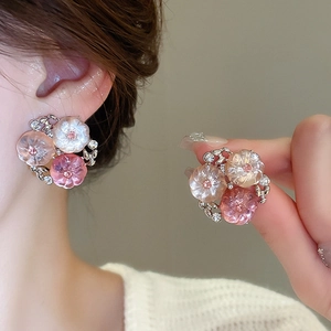 Close-up of pink and white gradient flower earrings with rhinestones and silver pins