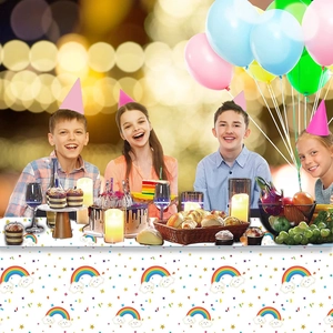 Rainbow clouds party tablecloth used at a kids birthday table with cakes and balloons