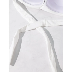 Detail of white halter bikini top showing fine knitted texture on marble background