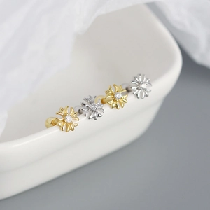 Macro shot of S925 silver cross stud earrings with sparkling cubic zirconia in gold and silver