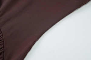 Close-up detail of dark brown soft elastic jersey fabric texture for women's slim dress