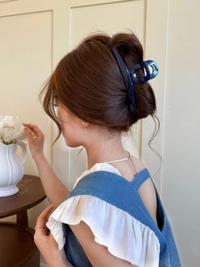 Detail view of large navy blue butterfly hair claw clip on elegant updo hairstyle