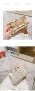 Macro view of champagne satin pleated evening bag with elegant pearl handle and metal clasp