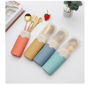 Flat lay of gold stainless steel cutlery sets in colorful wheat straw storage boxes