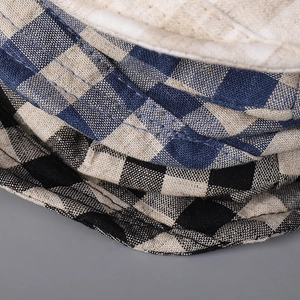 Close-up of retro plaid cotton linen fabric textures and stitching on beret hats