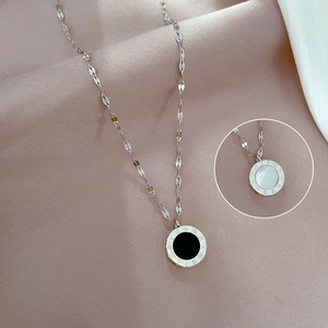 Close-up of double-sided pendant with Roman numerals on purple satin fabric