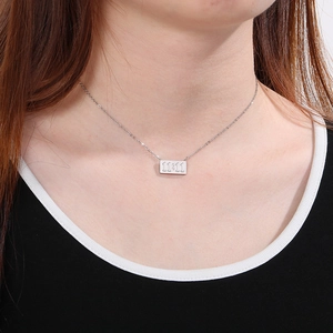 Gros plan d'un collier pendentif rectangulaire 11:11 argenté sur un mannequin
