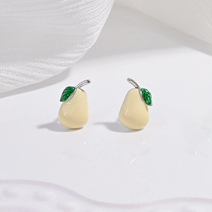 Vue macro de boucles d'oreilles en forme de poire en émail jaune crème et vert sur argent