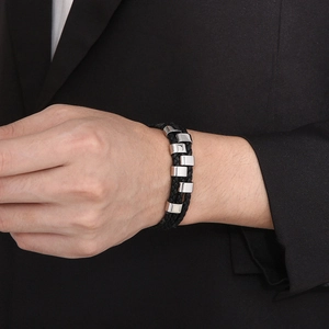 Detail of multilayer black leather woven bracelet with silver stainless steel sliders on wrist