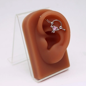 Detail eines rosa Herz-Zirkonia-Knorpel-Piercings am Ohrmodell mit Silber-Finish