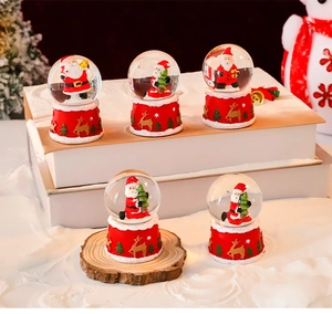 Detailed view of red Christmas snow globes with Santa Claus figurines and festive scenery