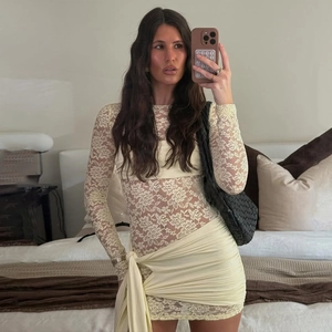 Elegant beige lace long sleeve bodycon dress with ruffled skirt and ribbon tie detailing