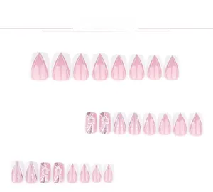 Dettaglio di unghie finte sfumate rosa e bianche con fiori 3D e accenti di glitter fini