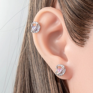 Silver heart and moon zircon stud earrings with pink gemstone on a female model