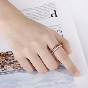 Bague 2-en-1 en or rose avec chiffres romains et diamants pavés sur une main