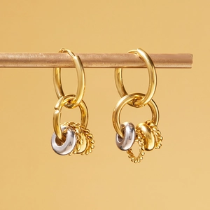 Detail of mixed-metal multi-hoop earrings featuring smooth silver and gold textured rings