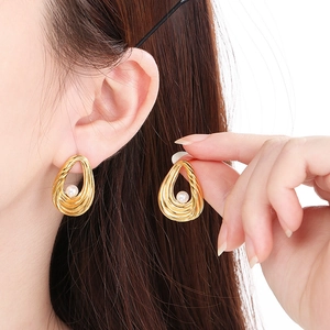 Detail of gold spiral earrings with pearls shown on a model for a stylish look