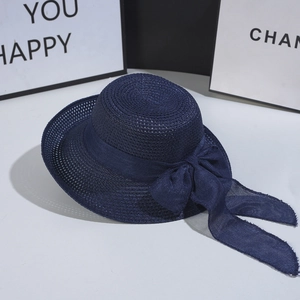 Detailed close-up of dark blue straw hat featuring breathable mesh weave and large bow