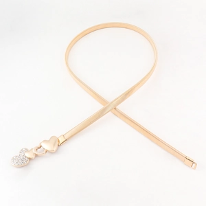 Detail of gold metal elastic chain belt with triple heart buckle and rhinestone inlay