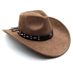Detail of brown faux suede cowboy hat featuring studded leather band and vintage medallion