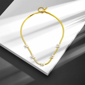 Golden flat snake chain necklace with five white shell butterfly pendants on stone