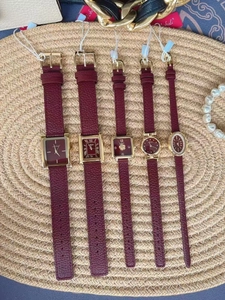 Close-up of luxury women watches with wine red leather straps and gold metal cases