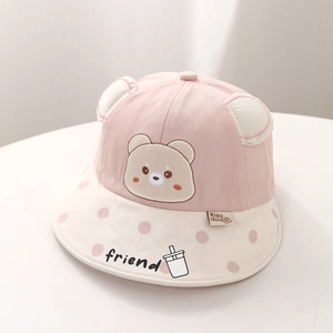 Détail d'un chapeau de soleil bébé bicolore avec oreilles d'ours et bord à pois