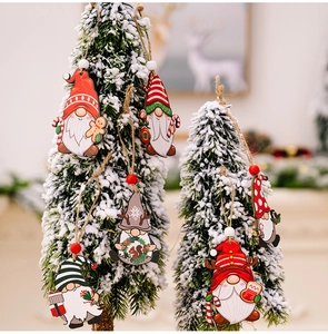 Detail of colorful wooden Christmas gnome ornaments hanging on a snowy tree with twine