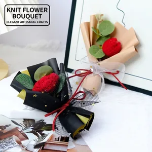 Handmade knitted red flower bouquet with green leaves in elegant gift wrapping paper