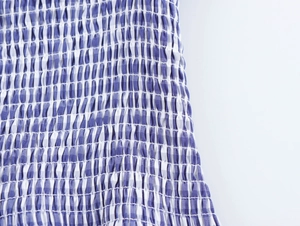 Vue détaillée du tissu à carreaux bleus et blancs avec une texture smockée élastique
