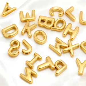 3D bubble initial pendants in 18K gold stainless steel on white satin background