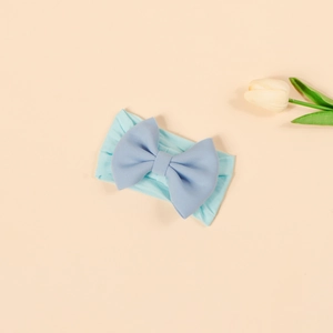Close-up of baby nylon headband featuring a blue contrast bow and elastic knit fabric