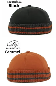 Detail von Docker-Mützen in Schwarz und Karamell mit grau-orange gestreiftem Strickrand