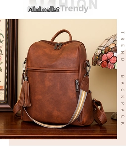 Detail of vintage brown leather backpack with tassel charm and colorful woven strap
