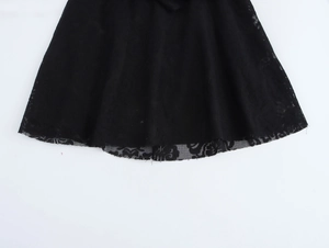 Détail du bord de la robe noire avec broderie en dentelle délicate et finition soignée