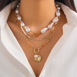 Baroque pearl and metal disc pendant layered snake chain necklace on female model