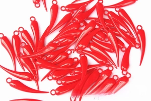 Close-up of vibrant red pepper pendants with metal loops for DIY New Year crafts