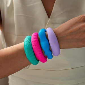 Detailansicht von vier bunten Silikon-Strukturarmbändern, getragen am Handgelenk