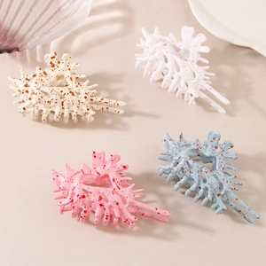 Niche conch-shaped hair claws in beige, white, pink and blue with speckled pattern