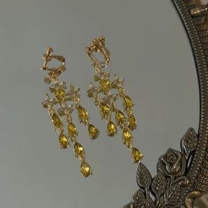Macro view of vintage gold tassel earrings featuring water drop gems and star motifs