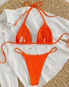 Detailed flat lay of bright orange ribbed bikini with halter top and high cut bottoms