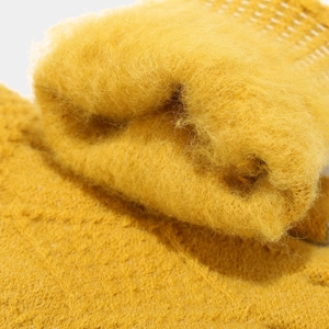 Detailed macro view of plush yellow winter knit material showing thick soft textures