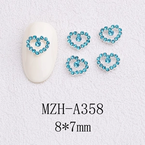 Macro shot of 8x7mm blue heart-shaped nail art charms with silver base and tiny rhinestones