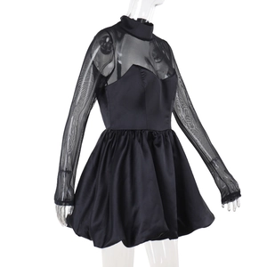 Detail of elegant black mini dress featuring sheer mesh sleeves and satin-finish bodice