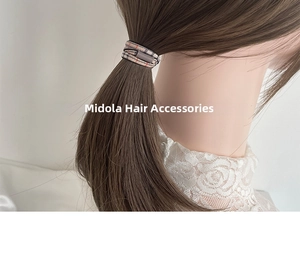 Detail of checkered fabric ponytail holder with buckle shown on a model's hair