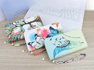 Three long zip wallets with colorful tree and bird prints on textured leather finish